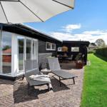 Terrasse mit Liegen, Sonnenschirm und Blick auf den Garten.
