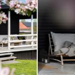 Terrasse mit Liegestuhl, Kissen und Decke. Schwarze Fassade, weiße Holzstrukturen und grüner Rasen.