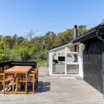 Terrasse mit Tisch und Stühlen neben einem Haus mit Glasfront.