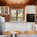 Kitchen with wooden walls, white cabinets, and red stand mixer.