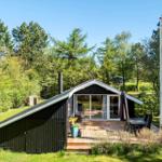 Wooden cabin with terrace, grill, and garden near forest