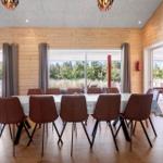 Großer Essbereich mit Holzwand und Tisch für acht Personen.
