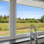 Küchenfenster mit Blick auf grünes Feld und Bäume