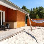 Haus mit Terrasse, Strand und Hängematte im Hintergrund.