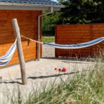 Hängemattenschaukel zwischen zwei Holzpfosten im Gartenbereich