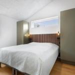 Schlafzimmer mit Bett, Holzfußboden und zwei Fenstern. Zwei Schränke an den Wänden.