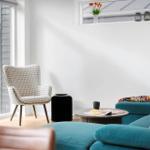 Ein Wohnzimmer mit blauem Sofa, einem Sessel und einem runden Tisch.