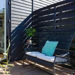 Deck with bench, plant, and view into the kitchen.