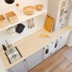 Kitchen with wooden countertop, sink, stove, and cabinet with glass door