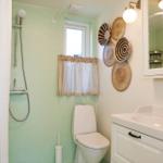 Bathroom with shower, toilet, and sink. Wall with decorative baskets.