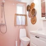 Bathroom with shower, toilet, and sink. Wall decoration of woven baskets.