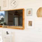 Wall with TV, picture frames, and round lamp shade.