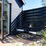 Terrace with two chairs and table. Glass door leads to interior space.