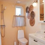 Bathroom with shower, toilet, and sink. Wall decoration with woven baskets.