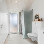 Badezimmer mit Toilette, Waschbecken und Dusche mit Glaswand.