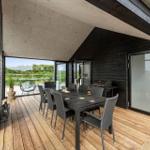 Terrasse mit Essbereich, Grill und Blick auf Landschaft.