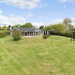 Modern villa with large garden and playground. House with glass facade and terrace.
