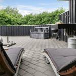 Terrasse mit Liegestühlen, Grill und Waschbecken an der Wand.