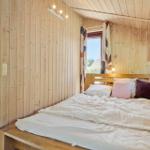 Bedroom with wooden walls and bed with pillows