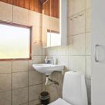 Bathroom with shower, sink, and toilet. Window with frosted glass.