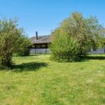 House with garden, trees, and clear sky.