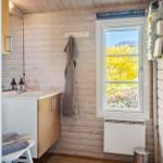 Badezimmer mit Holzwand, Fenster und Waschbecken
