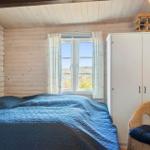 Schlafzimmer mit Holzwand, Bett, Fenster und Schrank.