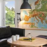 A living room with sofa, table, and map on the wall.