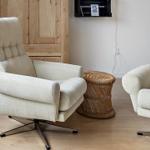 Two cream-colored chairs with metal base and round rattan table