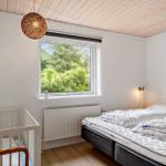 Bedroom with crib, bed, and window view of greenery.