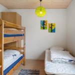 Room with wooden bed, mattress, wall art, and quilt.