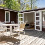 Deck with table and chairs, access to house through glass doors.
