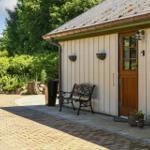 House with wooden door, bench, and paved path in the garden