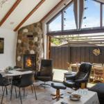 Living area with fireplace, dining table, and view of the terrace.