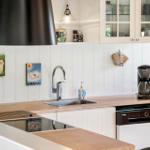 Kitchen with sink, coffee maker, and white cabinets.