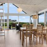 Dining room with wooden table and chairs, large windows, and view of the landscape.
