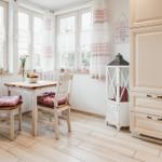 Essbereich mit Tisch, Stühlen und Küchenmöbeln an Fensterfront