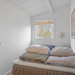 Bedroom with bed, window, and wall art. Ceiling with wood paneling.