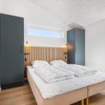 Schlafzimmer mit Bett, zwei Schränken und Fenstern