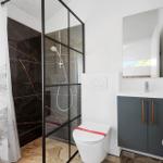 Badezimmer mit Dusche, Toilette und Waschbecken.