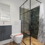 Badezimmer mit Dusche, Toilette und Waschbecken.