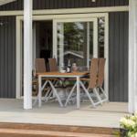Patio with dining table, chairs, and flowers. Entrance to the house.