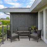 Deck with seating group, plant, and view of garden
