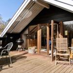 Terrasse mit Sitzgelegenheiten und Grill, Zugang zum Haus durch Schiebetüren.