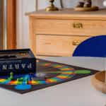 Tisch mit Brettspiel, Kerzen und Schrank im Hintergrund