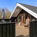Terrasse mit Tisch, Stühlen und Sonnenschirm. Holzveranda mit Grill und Sitzgelegenheit.