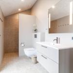 Moderne Badezimmer mit Waschbecken, Spiegel und Toilette.