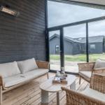 Terrasse mit Sitzgruppe, Holzboden und großem Fenster zur Aussicht