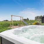 Ein Whirlpool mit Blick auf einen Spielplatz und ein Haus.