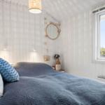 Bedroom with bed, window, and wall mirror